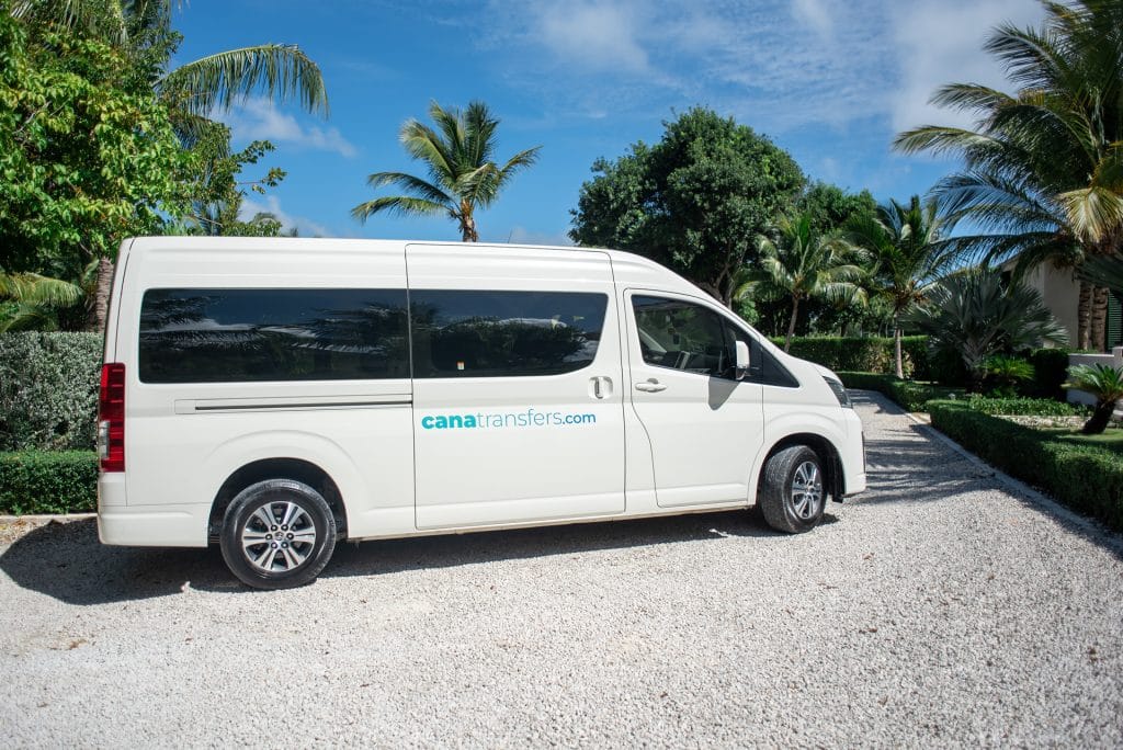 Side view of a white Toyota Hiace of Cana Transfers on a tropical driveway in Punta Cana